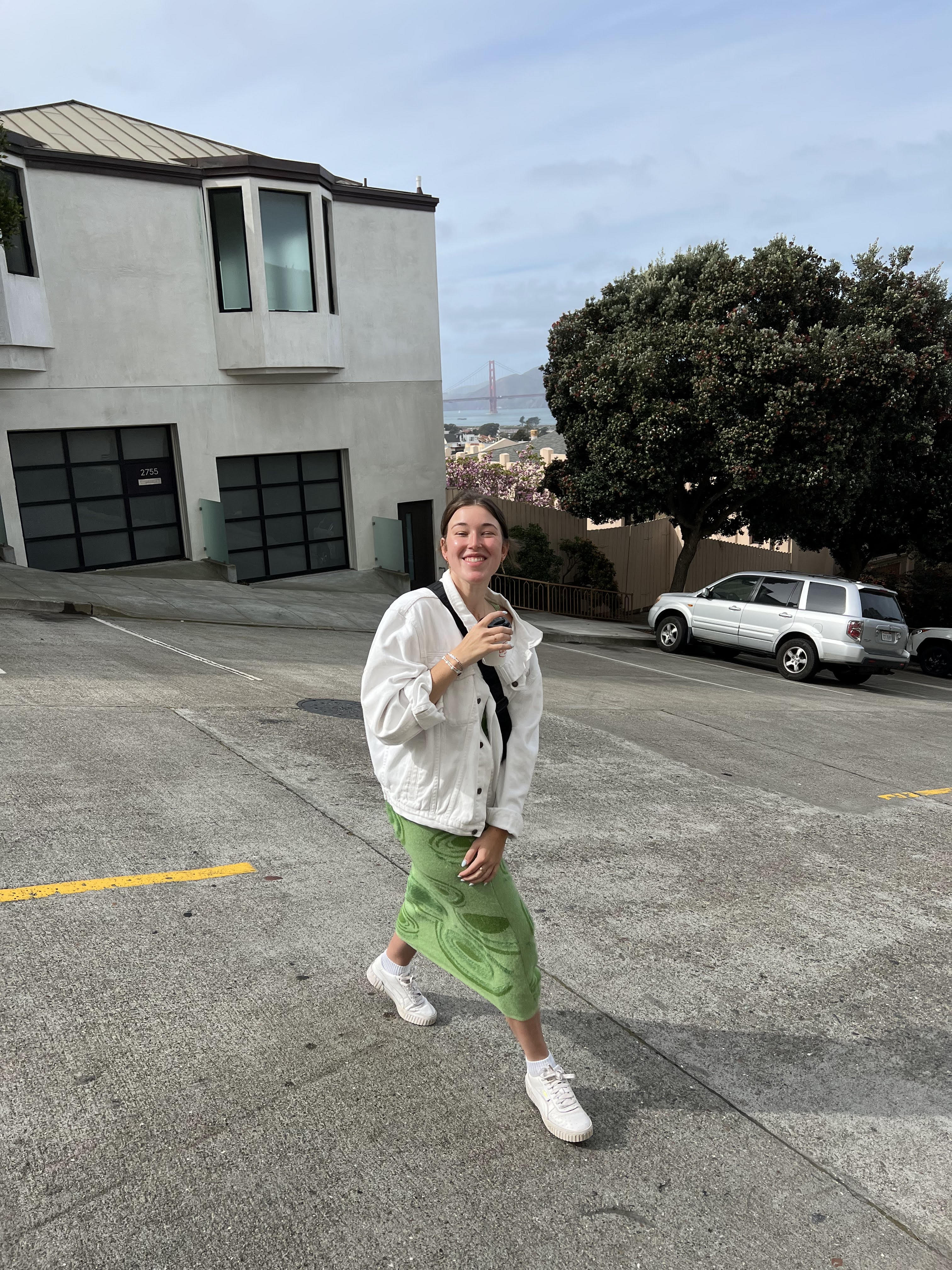 :img Elizabeth on a street in San Francisco with a cup of coffee, 80%, width